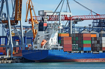 Container stack and ship under crane bridge