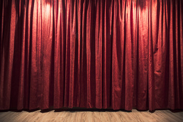 Red theater curtain with a wood stage floor