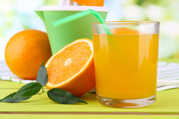 Glass of juice, citrus press and ripe orange
