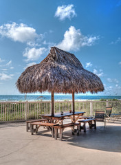 Beach table and chairs with a hay parasol