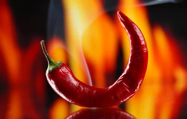 Fotobehang Chili Pepers Red hot chili pepper on fire background  © Africa Studio