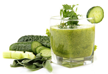 Glass of green vegetable juice and vegetables isolated on white