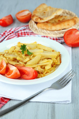 Fried potatoes on plate on wooden table close-up