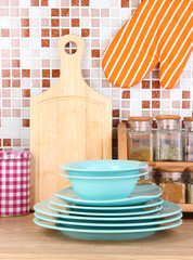 Plates in kitchen on table on mosaic tiles background