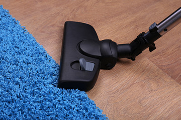Vacuuming carpet in house