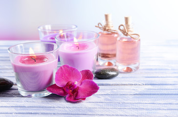 Fototapeta na wymiar Beautiful colorful candles, spa stones and orchid flower,on
