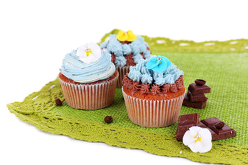 Tasty cupcakes with butter cream,on color napkin, isolated