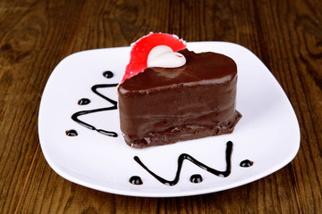 Sweet cake with chocolate on plate on table close-up
