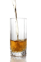 Juice pouring into glass isolated on white