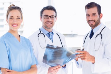 Portrait of doctors with x-ray report at medical office