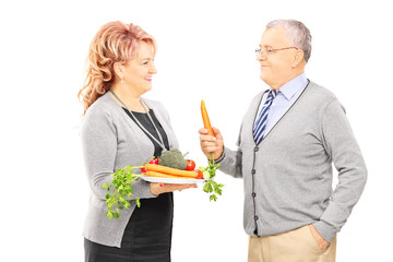 Middle aged couple standing close together and holding a healthy