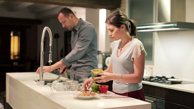 Young couple in the kitchen, woman preparing food