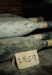 Old bottles of wine in old cellar, on dark  background
