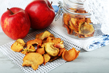 Dried apples in glass jar, on color wooden background