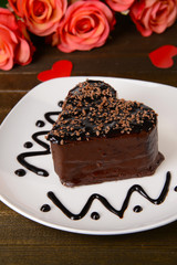 Sweet cake with chocolate on plate on table close-up