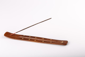 Incense stick on a wooden support on a white background