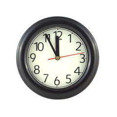 Big round wall clock shows almost twelve isolated close up