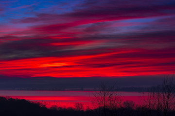Fototapeta na wymiar Crimson Sunrise Over the Lake