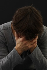 Depressiver hat sein Gesicht in Hände verborgen