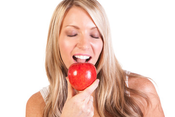 Head shot of woman holding apple against white background