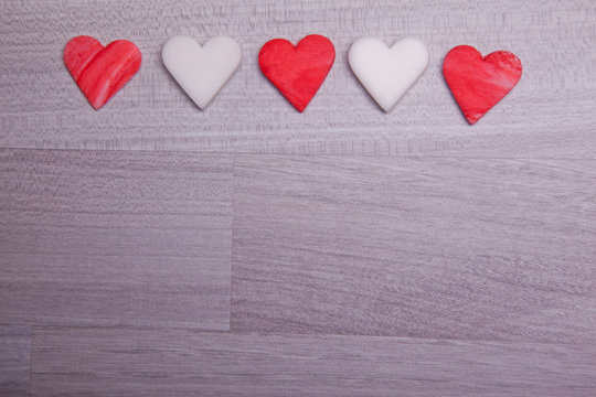 five red and withe fondant heart on wooden