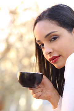 Beautiful woman holding a cup of coffee outdoor
