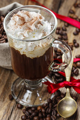 Irish coffee on wooden table among coffee beans