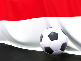 Naklejka premium Flag of yemen with football in front of it