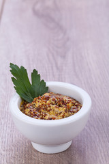 frischer gelber grobkörniger senf mit petersilie dekoriert