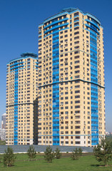 Modern apartment building after gray metal fence near park