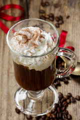 Irish coffee on wooden table among coffee beans