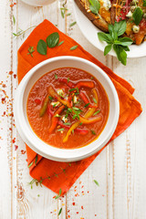 Pepper and tomato soup with fresh herbs and cheese