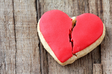 Cracked cookie as a concept of broken heart and breakup - obrazy, fototapety, plakaty