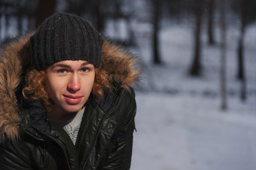 Closeup portrait of smiling young man in the winter park
