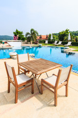 Obraz na płótnie Canvas Table and chairs besides the pool