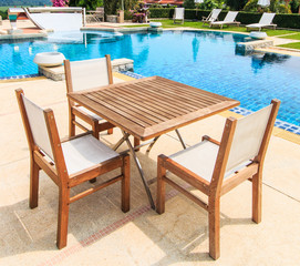 Fototapeta na wymiar Table and chairs besides the pool