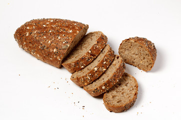 Slices of rustic herb bread with seeds on white background