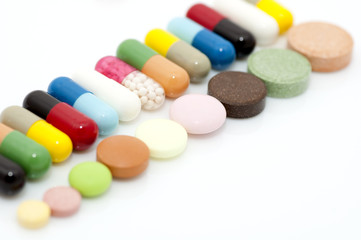 Assortment of capsules and tablets in row close up