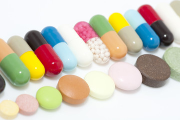 Assortment of capsules and tablets in row close up