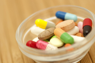 Various drugs (tablets, pills, capsules) in small salad bowl