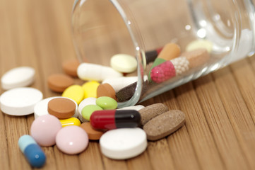 Various drugs (tablets, pills, capsules) in small canted glass