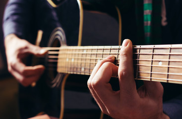 Fototapeta na wymiar Człowiek odtwarzania muzyki na czarnym drewnianym gitara akustyczna
