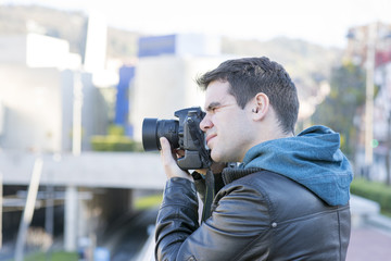 Portrait of photographer with camera  in action in the street.
