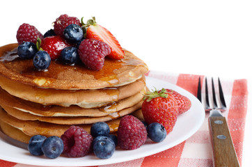 Pancakes with berries and honey over white
