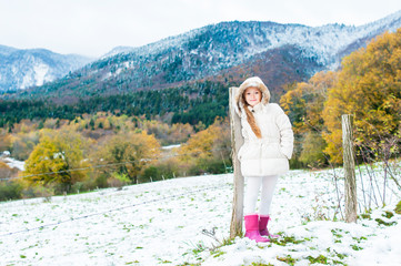 Winter portrait of a cute little girl in a white jacket