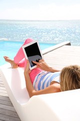 Woman in deckchair using digital tablet