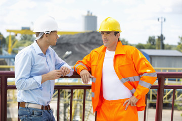 Architects standing against railing at construction site