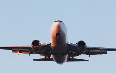 Naklejka premium Landing white aircraft on the blue sky background
