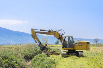 Excavator standing infield with raising bucket