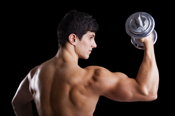 Fototapeta na wymiar Portrait of a strong man lifting weights against a dark backgrou